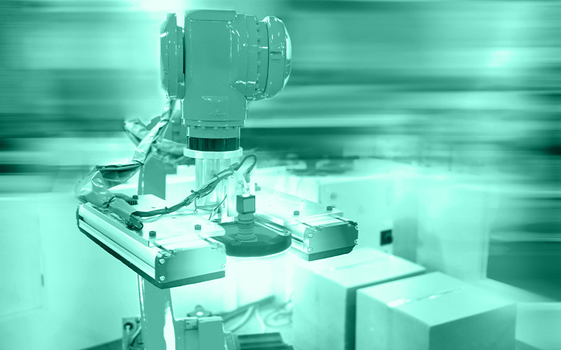 ein industrielles Bildverarbeitungssystem ist an einem Roboterarm montiert und prüft Kartons und Verpackungen visuell